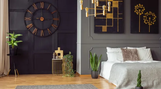 Dark bedroom interior with fresh plants, carpet on floors, double bed, and gold lamp | Merry Maids