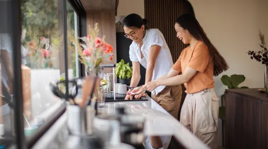 Young couple doing dishes together, laughing and enjoying a clean home. | Merry Maids®