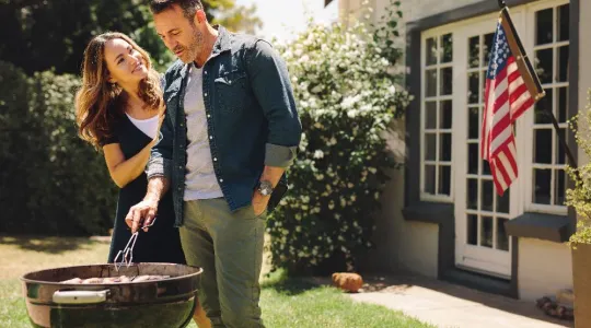 Husband and Wife Grilling with American Flag