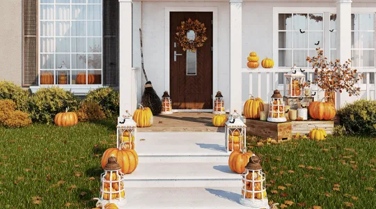 House decorated for Halloween with fall leaves in yard.