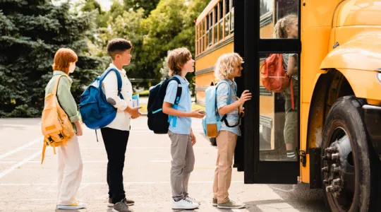 Kids waiting in line to get on a school buss | Merry Maids