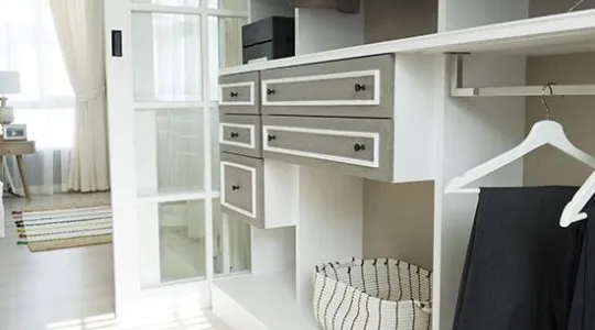 Organized white and grey closet with few clothes hanging | Merry Maids