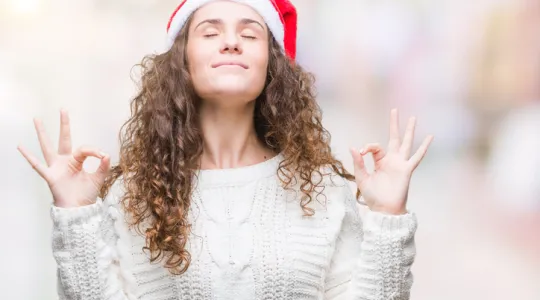 Young woman wearing christmas hat over isolated background relax and smiling with eyes closed doing meditation gesture with fingers | Merry Maids