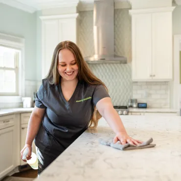 Merry Maids Team Member Cleaning Kitchen Island