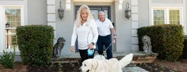 Couple outside home with dog