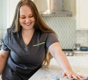 Merry Maids team member wiping kitchen counter