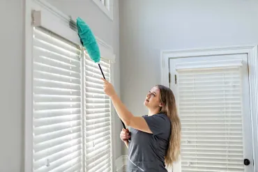 Merry Maids team member dusting window