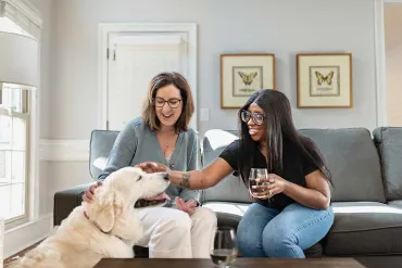 Two ladies on couch with dog