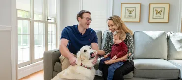 Family on couch with dog.