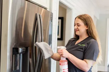 Merry Maids team member cleaning fridge