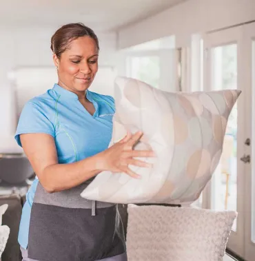 Merry Maids team member with pillow
