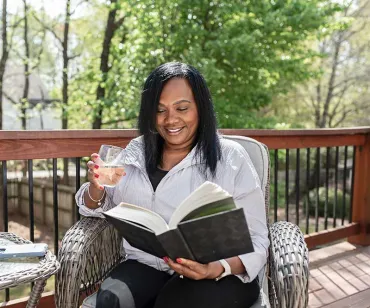 Woman holding drink on deck