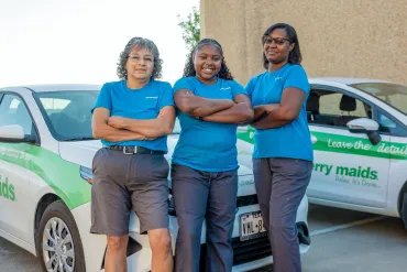 merry maids standing in front of a branded vehicle