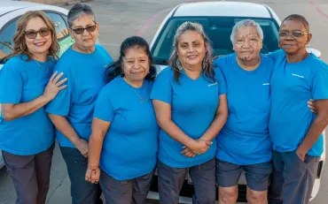 merry maids standing in front of a branded vehicle