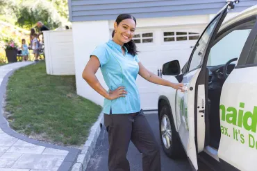 Merry Maids team member in front of vehicle