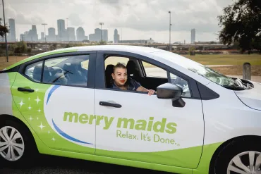 merry maid in a branded vehicle in front a skyline