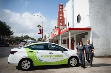 merry maids standing beside a branded vehicle