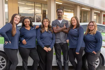 merry maids posing by branded vehicles