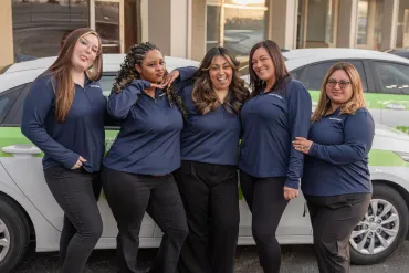 merry maids posing by branded vehicles