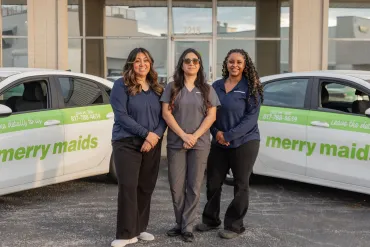 merry maids posing by branded vehicles
