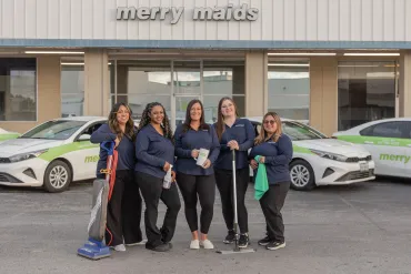 merry maids posing by branded vehicles