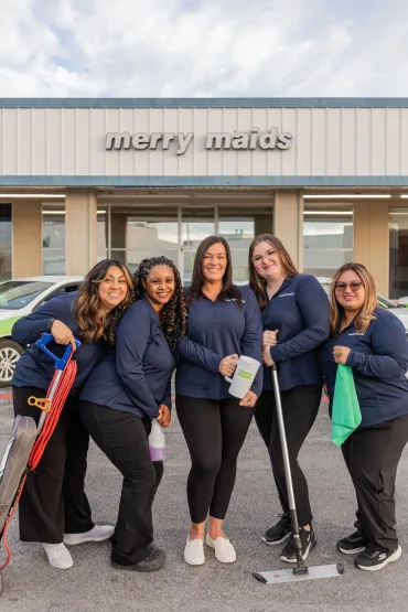 merry maids posing by branded vehicles