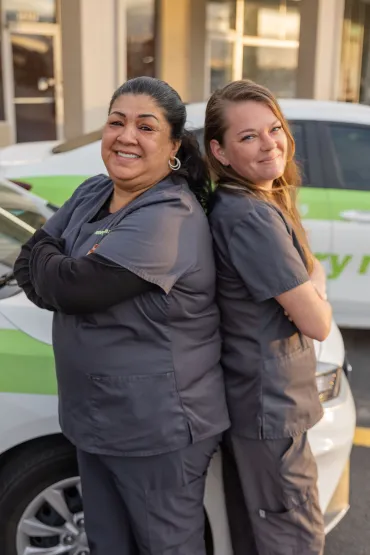 merry maids posing by branded vehicles