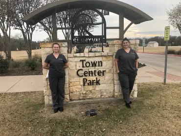 merry maids posing by a sign