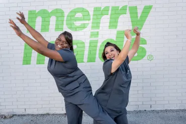 merry maids posing by a white brick wall
