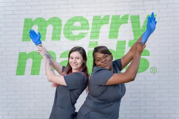 merry maids posing by a white brick wall