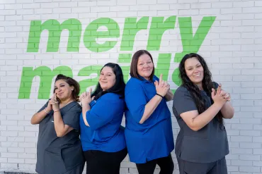 merry maids posing by a white brick wall