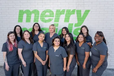 merry maids standing in front of a white brick wall