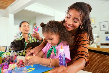 mom, grandma, girl and dog crafting
