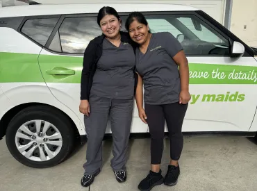 merry maids posing by branded vehicles