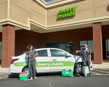 merry maids posing by branded vehicles