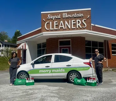 merry maids posing by branded vehicles