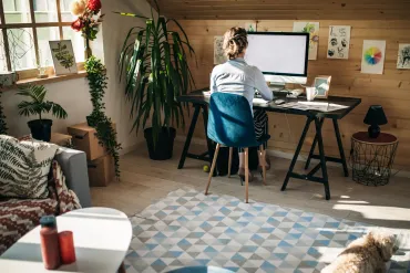 Woman working at home office with dog.