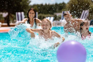 Young child playing in a pool with mom and sister | Merry Maids